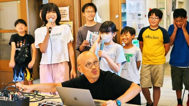 すわ公園交流館ホールで「こども四日市」ドキュメンタリー映画の主題歌レコーディングに臨む子どもたちと機材を操作する小林渚さん