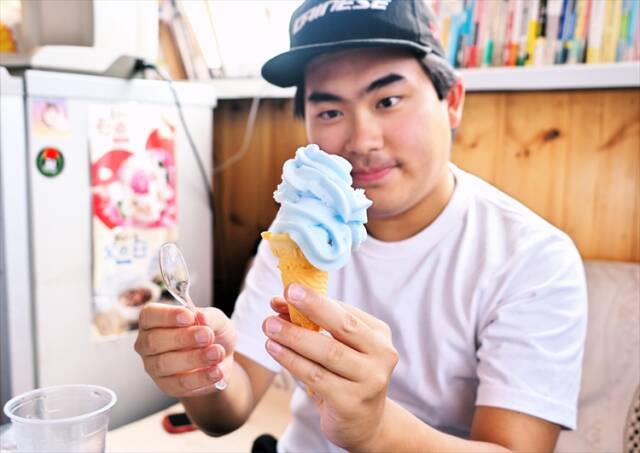 ラムネ味の芸術的ソフトクリームを手に興味深げな滋賀県大津市から訪れた男性客