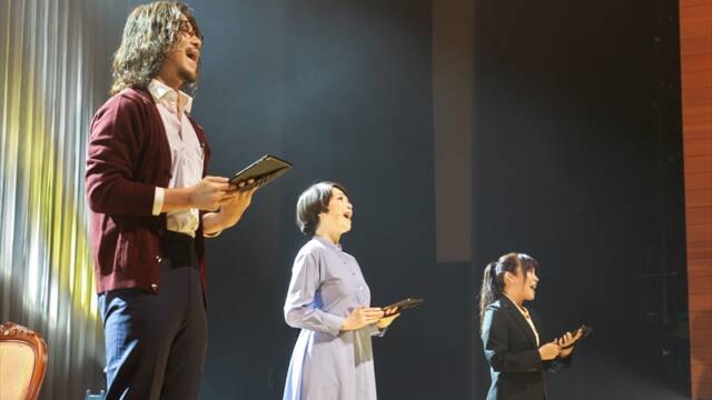 四日市市文化会館で上演されたリーディングミュージカル「Play a Life」の舞台。俳優3人がタブレットを手に歌唱している。