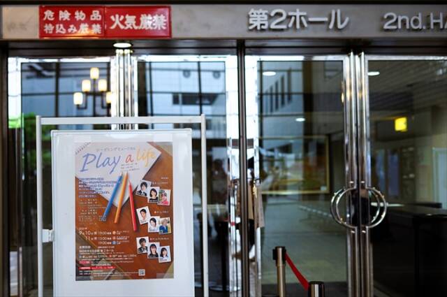 四日市市文化会館第2ホールの入口に掲示された「Play a Life」の公演ポスター。