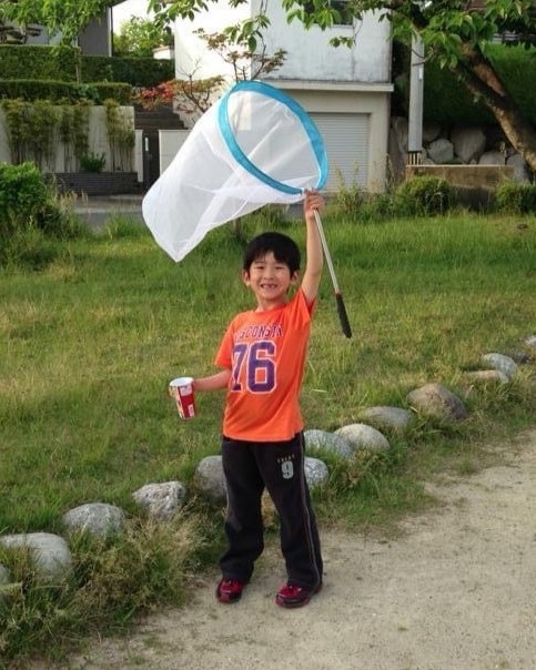 虫取り網を手に笑顔を見せる幼少期（5歳頃）の椎名奏衣さん＝椎名さん提供