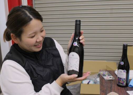 1本ずつ手作業でラベル貼り、11月30日の初披露に向け、四日市の水沢ワイン