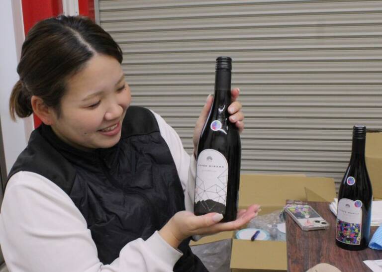 1本ずつ手作業でラベル貼り、11月30日の初披露に向け、四日市の水沢ワイン