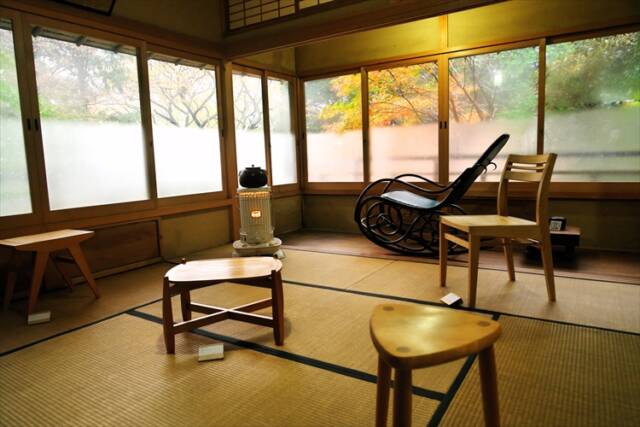 鎮驚庵の展示室で家具作品と紅葉が調和する展示風景