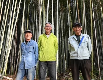 整備した竹林の前に立つ寺田代表理事（中央）とメンバー