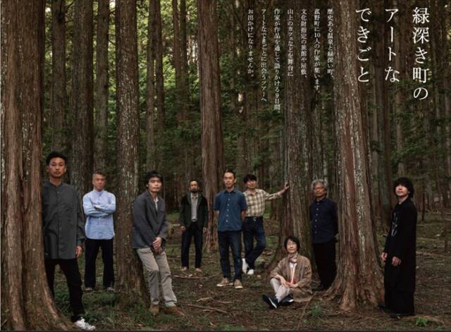 菰山展の公式チラシ。杉林に出展作家たちが立ち、右上には縦書きで「緑深き町のアートなできごと」と記されている。自然とアートの共鳴をテーマにしたビジュアル。