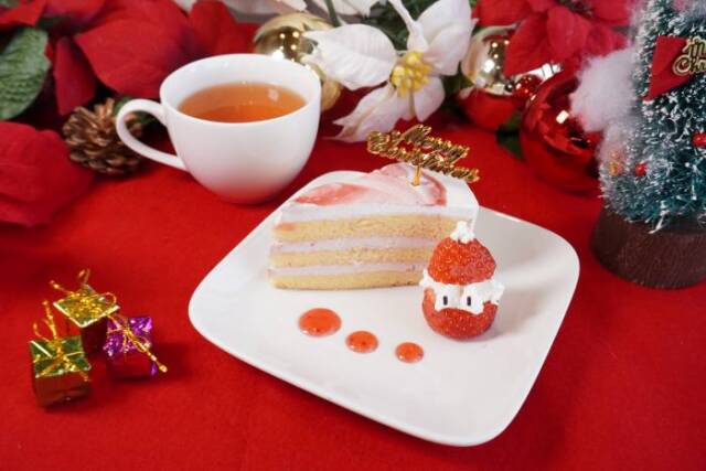 いちごで作ったサンタクロースとショートケーキ。その後ろの紅茶やクリスマスのオーナメントがある