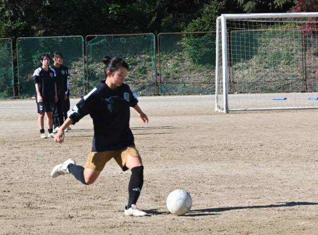 キックの練習をする部員、その背後で順番を待つ部員がいる