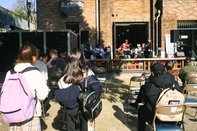 ウッドデッキ前でライブ演奏を楽しむ観客。子どもの姿も見える