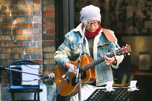 ギターを構えて歌うトビー前田さん。観客の歓声を受けながら演奏している