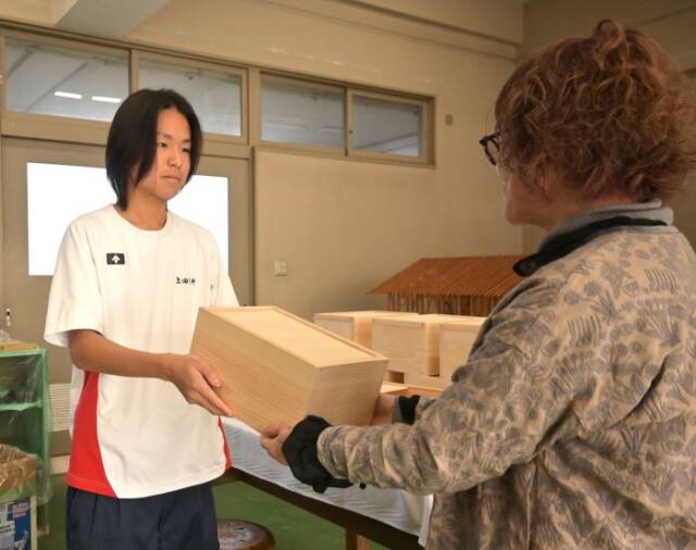 出来上がった棺を洲上さんに手渡しする部長の上田さん