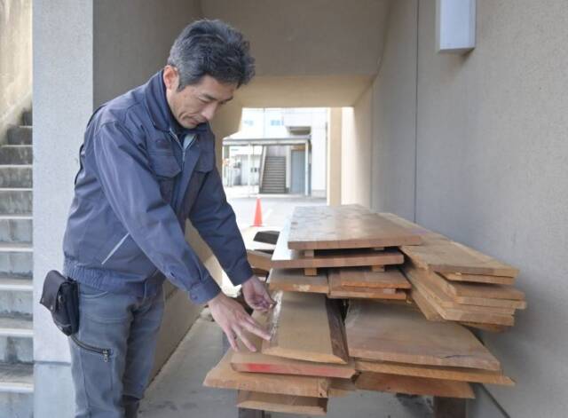 縦に積まれた木材を確認する伊藤教諭