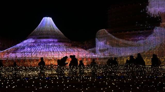 今年のテーマ「ZIPANGU」 ～ ジパング～の富士山のイルミネーションの前に人影がある