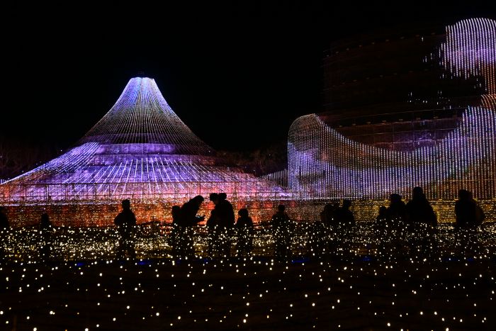 今年のテーマ「ZIPANGU」 ~ ジパング~の富士山のイルミネーションの前に人影がある
