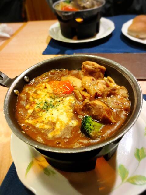 チーズがかかった焼カレーの後にハンバーグとパンがある