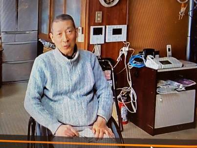 車いすに座って話をする男性