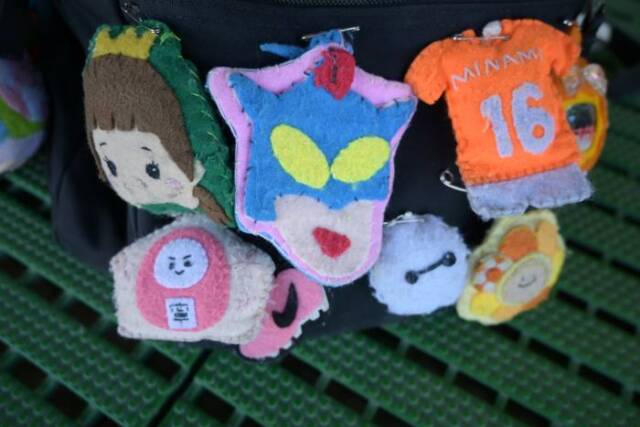 背番号のついた南高校のユニフォームを模したものなど、たくさんの手作りのお守りが複数鞄に取り付けられている
