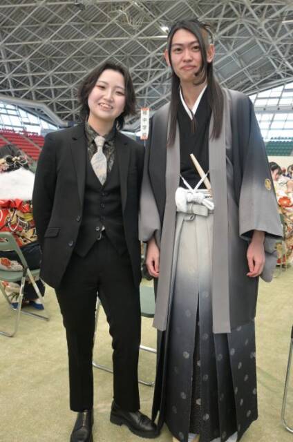 パンツスーツの女性と、羽織袴姿の男性のカップル