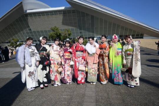 華やかな振袖を着た女性が9人並ぶ