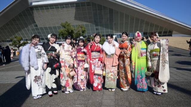 華やかな振袖を着た女性が９人並ぶ