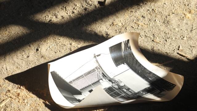 三重県菰野町の古民家「おやまの家」の土間に直接置かれた、お茶で染めた写真作品