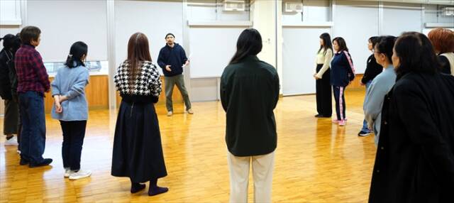 三浜文化会館で行われた「銀河鉄道の夜」朗読公演の稽古で、輪になって構成・演出の志賀亮史さんの話を聞く市民出演者たち