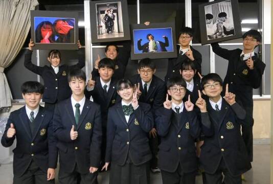 作品の写真パネルを手にする部員と笑顔で写真に納まる部員