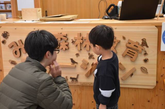 看板に触る子どもと見守る部員