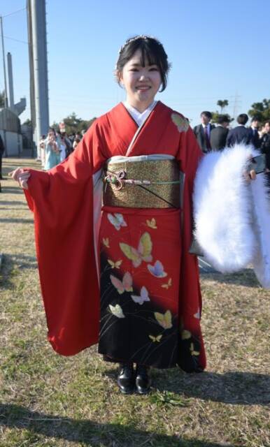 赤い「ママ振袖」に白いショールを持つ女性