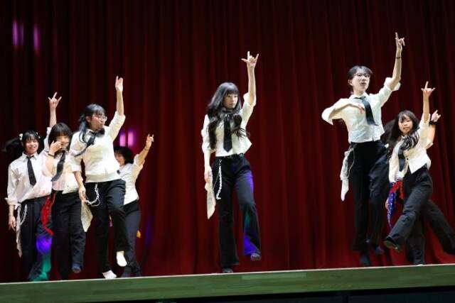 白と黒の衣装を着て文化祭のステージで踊る部員