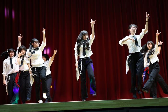 白と黒の衣装を着て文化祭のステージで踊る部員