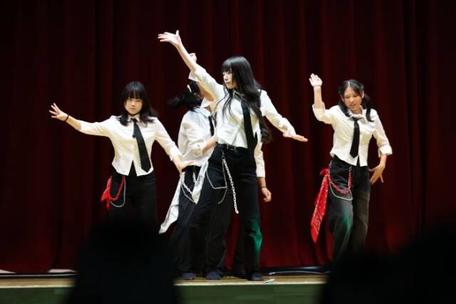 白と黒の衣装を着て文化祭のステージで踊る部員