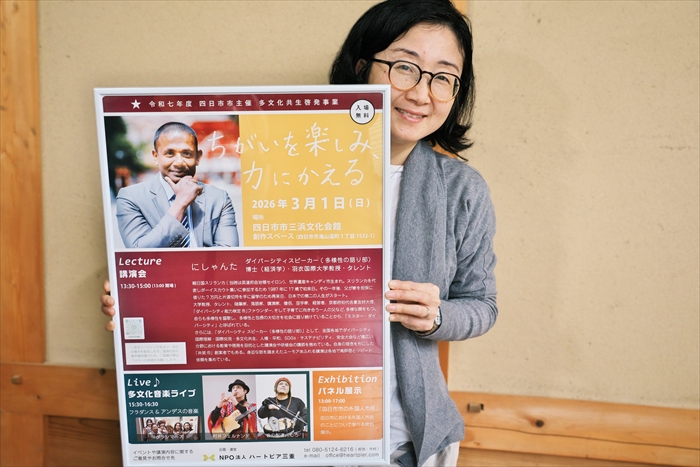多文化共生イベントのポスターを手に、来場を呼び掛けるハートピア三重の佐野愛さん