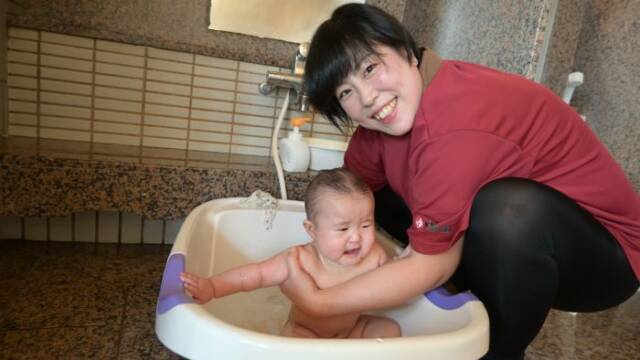 温泉でベビーバスを使って赤ちゃんをお風呂に入れる大川さん
