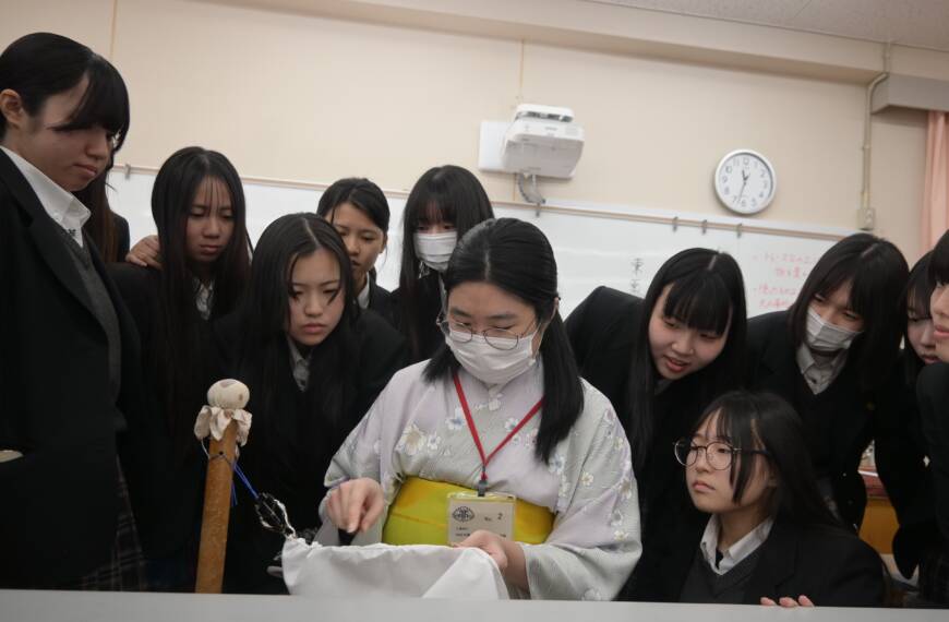 諸岡さんの説明を興味深く聞く生徒が諸岡さんの後ろからのぞき込む様子