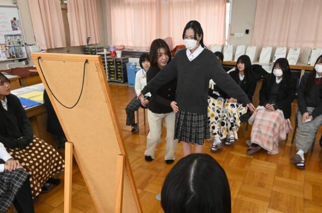 生徒の腰回りに手を当て骨格診断をする清水さん
