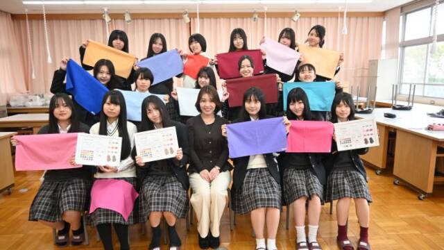 パーソナルカラー診断に使う色見本の布を手にし、清水さんと記念写真を撮る生徒
