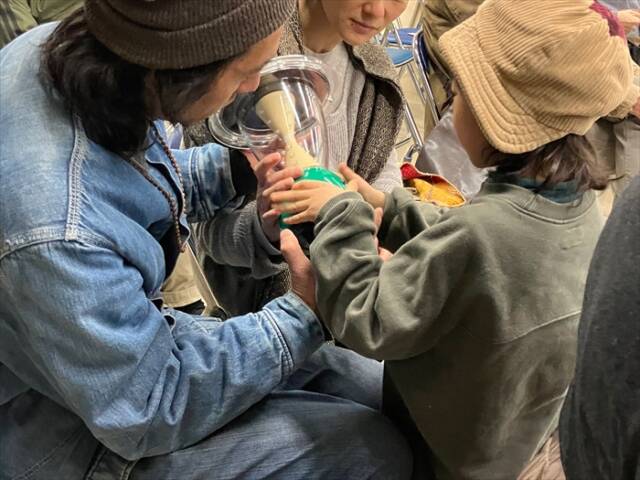 昨年のイベントで、難民キャンプで使用されているランタンを手に取る来場者