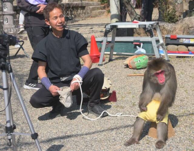 猿周氏の猿と猿回し芸人が座っている