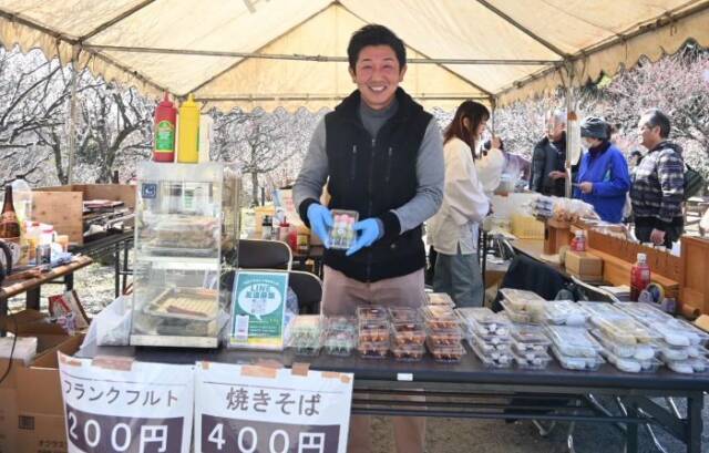 出店で団子を手にする人