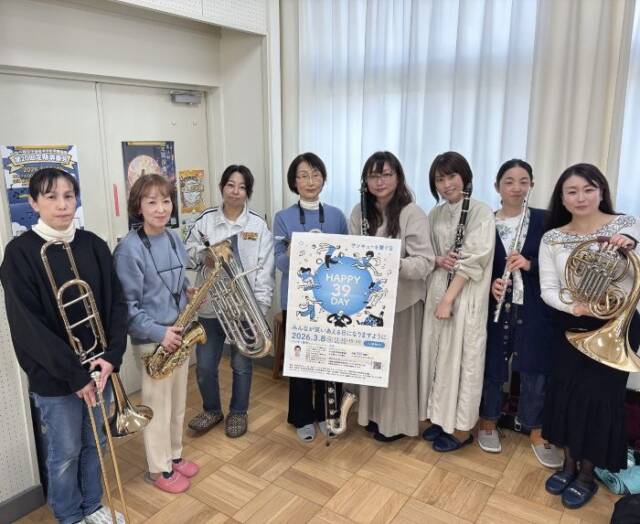 楽器とポスターを手にする三重サルビア楽団のメンバー８人