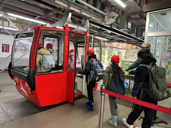 ロープウエイのゴンドラに乗り込む子どもたち