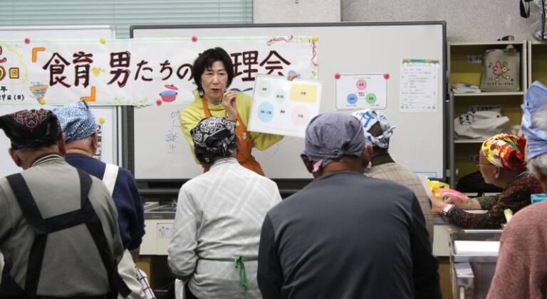 四日市の「食育・男たちの料理会」が開催200回に、初回からの講師に花束を贈る