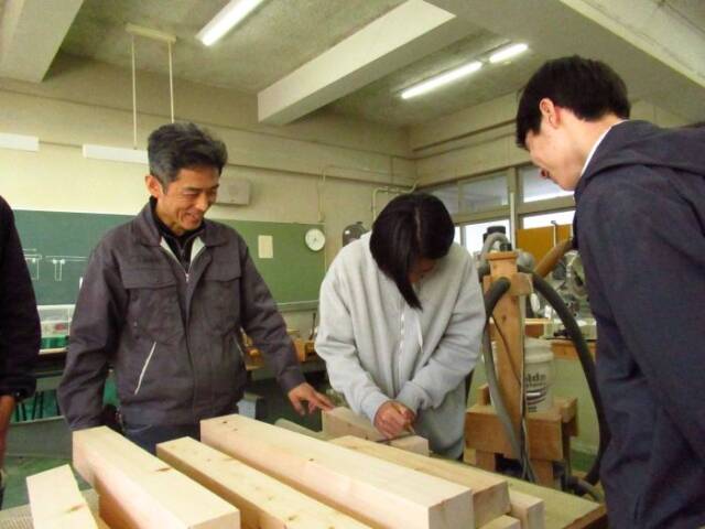 部員の作業を笑顔で見守る伊藤教諭