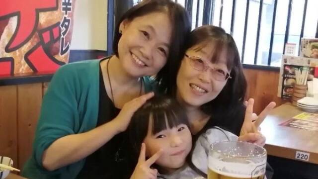 藤島さんと妹の森川さんと藤島さんの孫が焼き鳥屋で笑顔で写真を撮っている