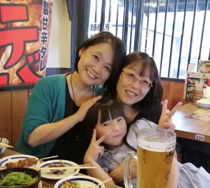 藤島さんと妹の森川さんと藤島さんの孫が焼き鳥屋で笑顔で写真を撮っている