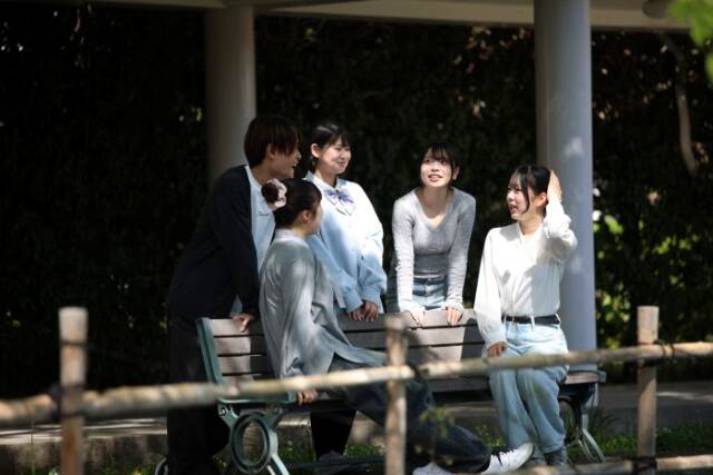 校内のベンチに座って話をする通信制の生徒5人