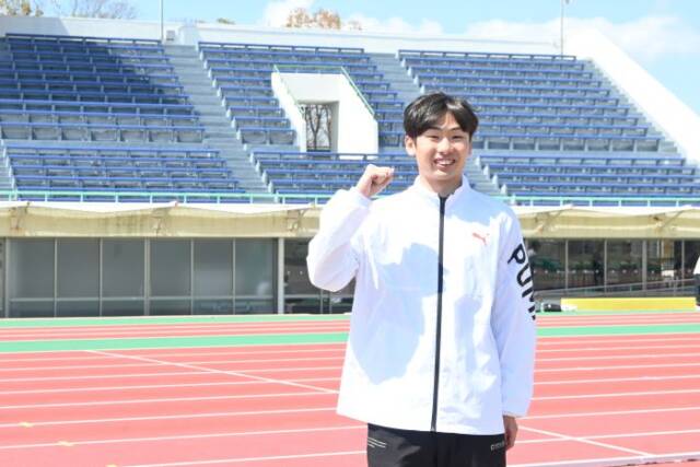 競技場のスタンドの前でガッツポーズをとる向井さん