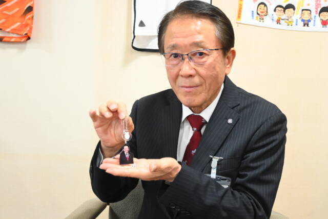 自身のキーホルダーを手にする諸岡菰野町長