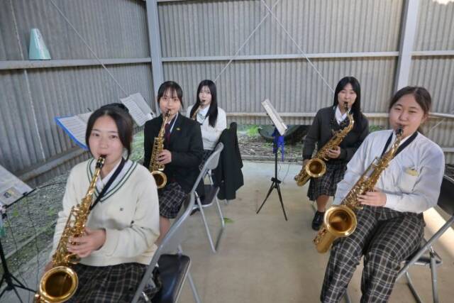 アルトサックスとテナーサックスの練習をする5人